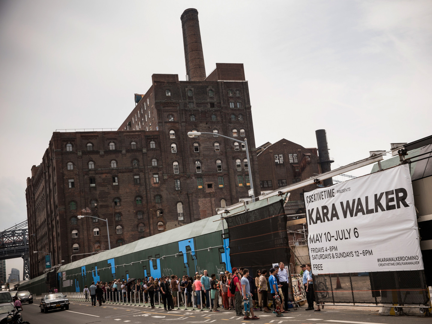 Visitors wait in line for the Kara Walker exhibit on May 10, opening day. The show was housed in a former Domino Sugar refinery. Inside, visitors described the building as "cathedral-like" and "creepy," and said it smelled like a bakery