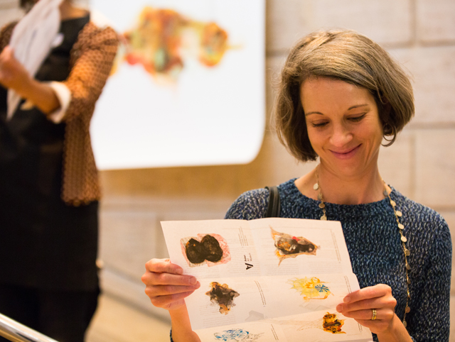 A museum visitor reads the <b>Re:depiction</b> handout; Photo courtesy of the Asian Art Museum