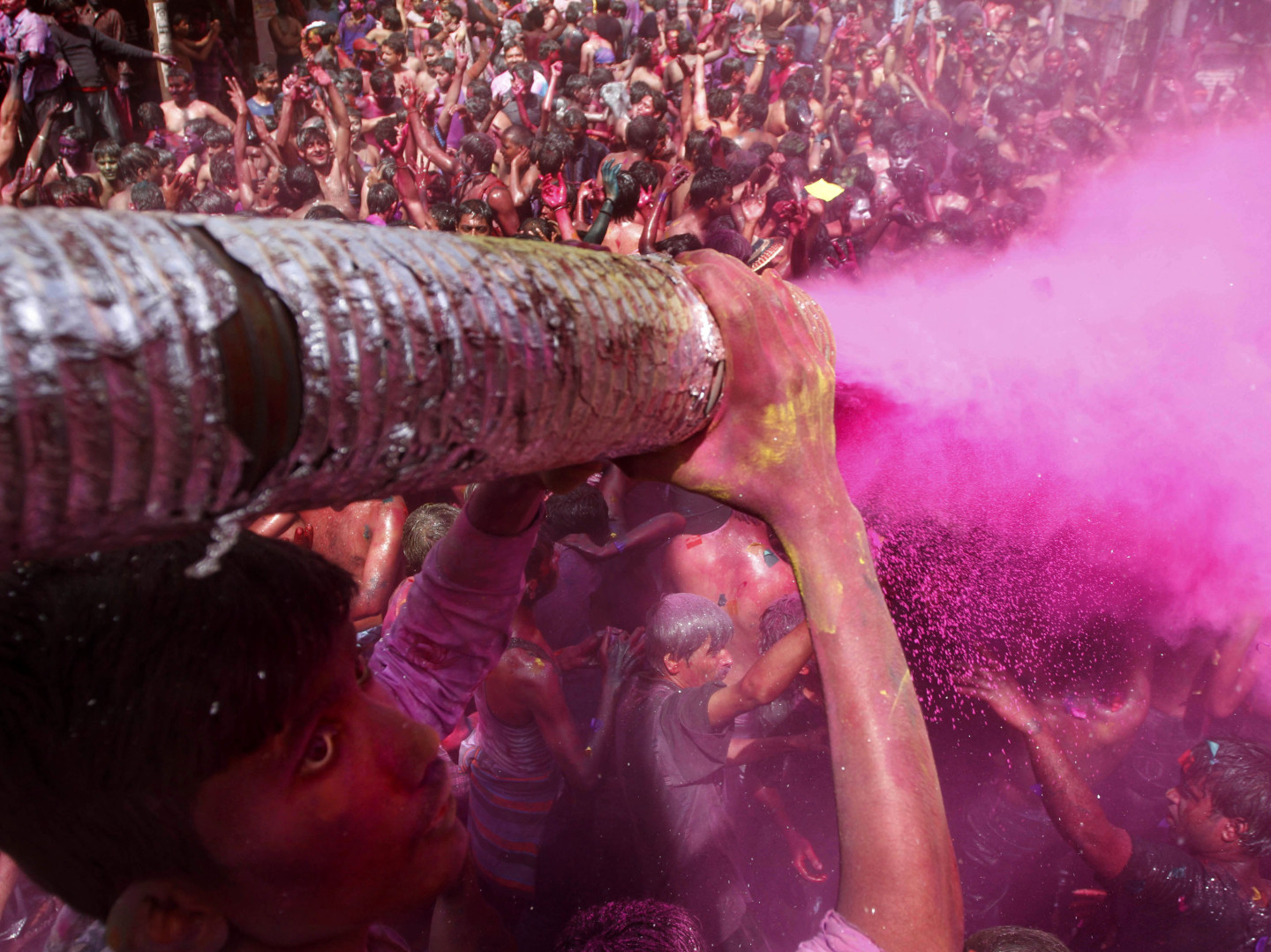 A man sprays colored dye on people dancing during Holi celebrations in India in 2012. Holi, the Hindu festival of colors, also heralds the coming of spring -- a detail that partiers at the Shout Color Throw might miss.