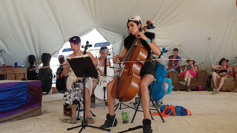 Cellists with the PlayaPops Symphony warm up before their debut performance at Burning Man this year (2014).