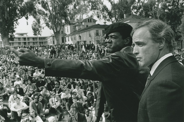 Bobby Seale and Marlon Brando at the at the memorial for Bobby Hutton, April 12, 1968, at Merritt Park in Oakland. (Photo: Jeffrey Blankfort)