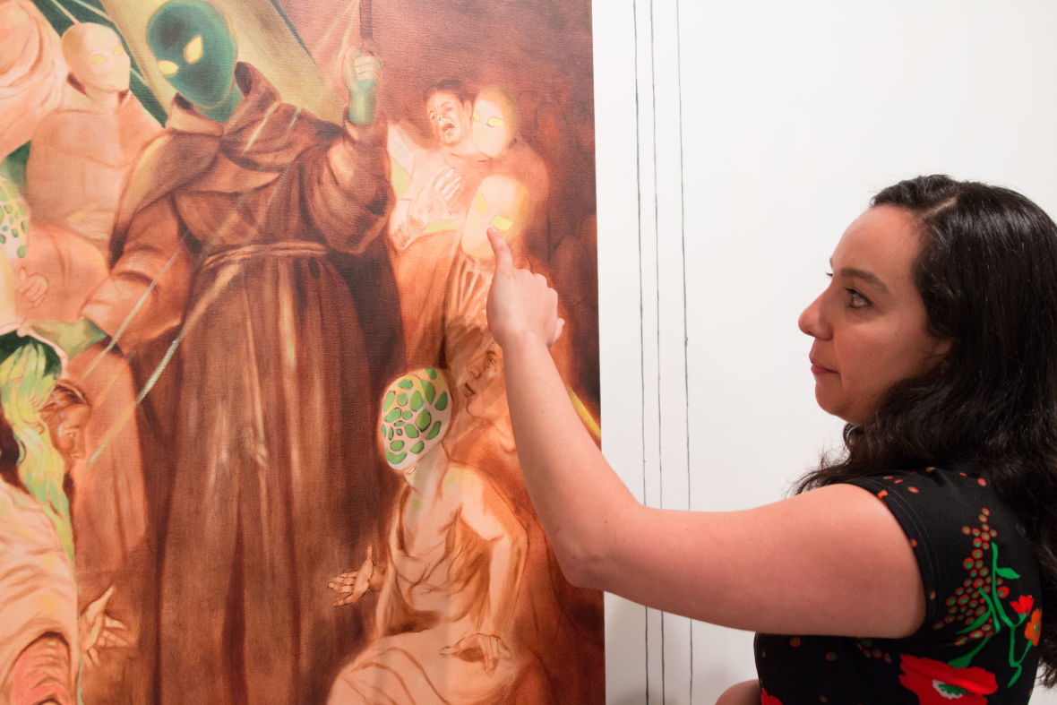 Katie Dorame points out details in 'Neophyte Baptism,' 2015. (Photo: Jeremy Raff/KQED)