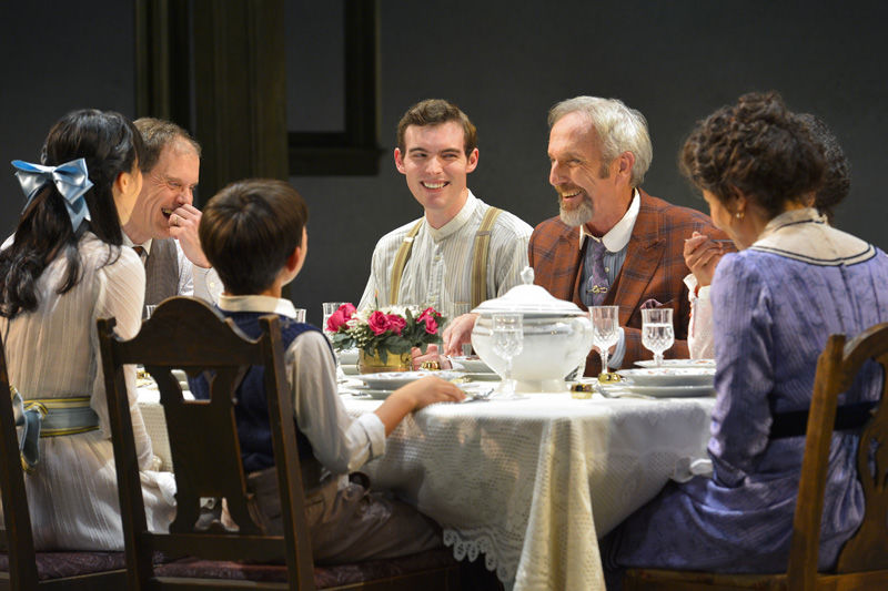 Sid Davis (Dan Hiatt, pictured in orange suit) indulges the Miller family with food gags at the dinner table in Eugene O'Neill's Ah, Wilderness!, performing at A.C.T.'s Geary Theater through Sunday, November 8.
