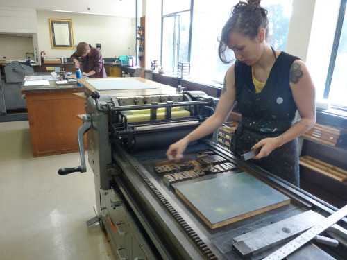 Beck Levy and Isabel Duffy (in the background) work on the presses at Mills College. (Photo: Jess Heaney)