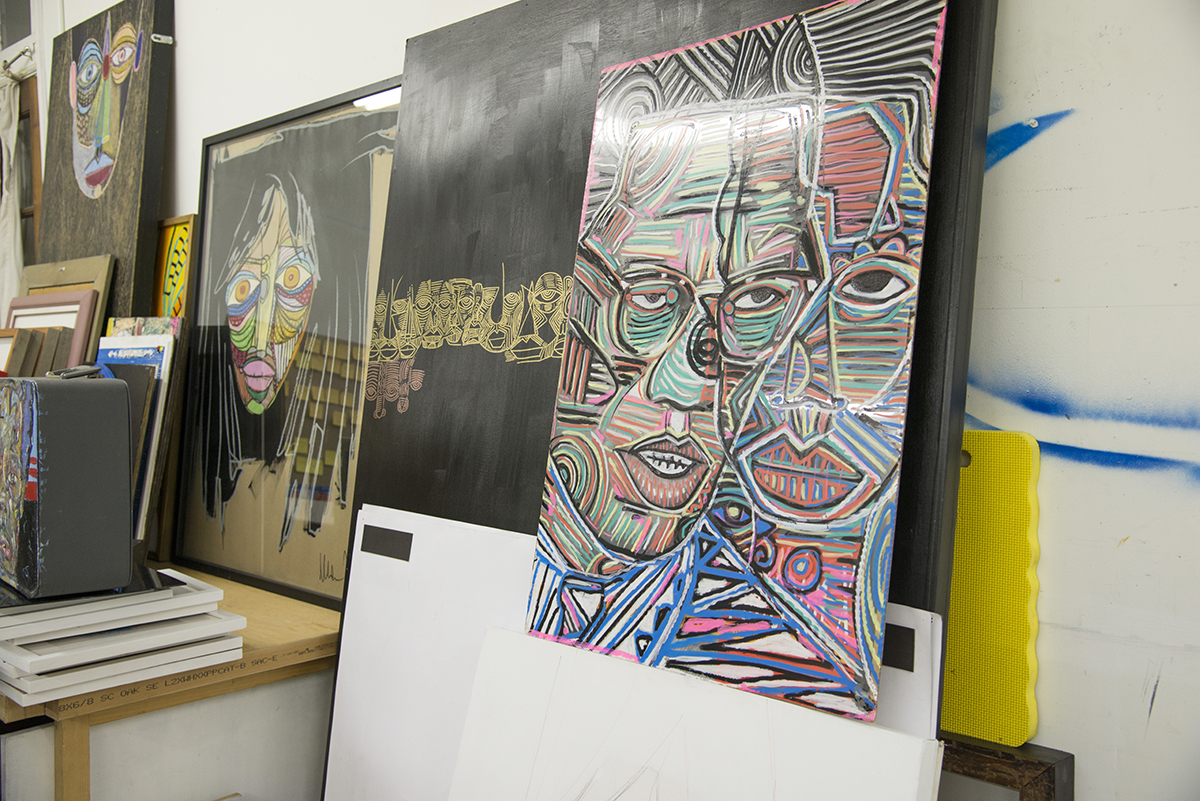 Paintings line the walls of Tesfai's studio.