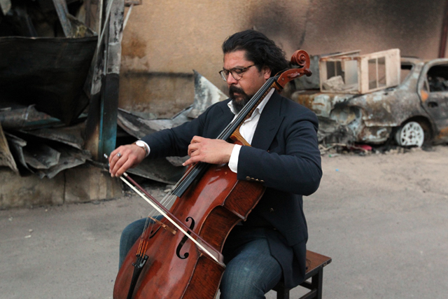 Karim Wasfi, former director for the Iraqi National Symphony Orchestra, plays on his cello next to debris in Baghdad's Sunni Adhamiya district on May 15, 2015, in a symbolic act of protest against violence.