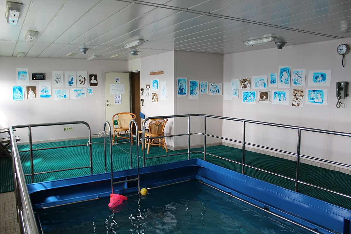 The artist's "studio" on board the container ship, with works on display.