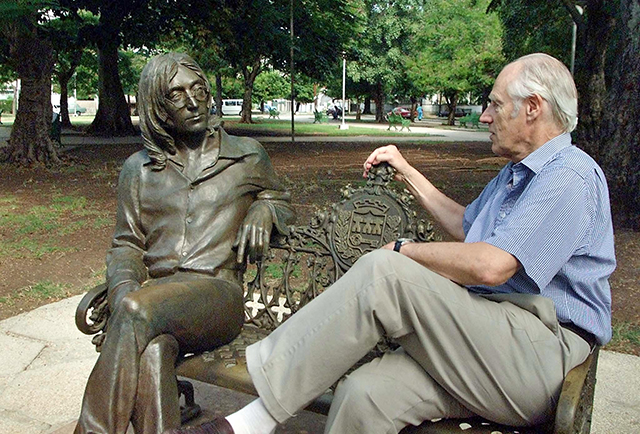 Sir George Martin (R), known world-wide as the fifth Beatle from his collaborations with the famous musical group, shares a seat with a statue of John Lennon in a park of Havana, Cuba