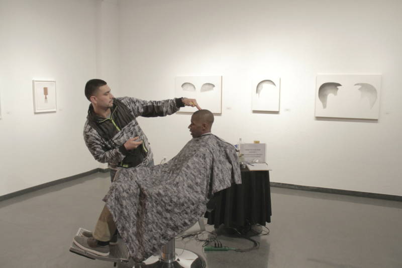 Jose the Barber, giving a MACLA visitor a close crop fade haircut at the Custom Lives opening in December 2015.