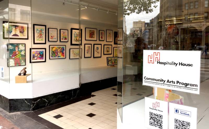An art show in the window of the Community Arts Center at Hospitaity House