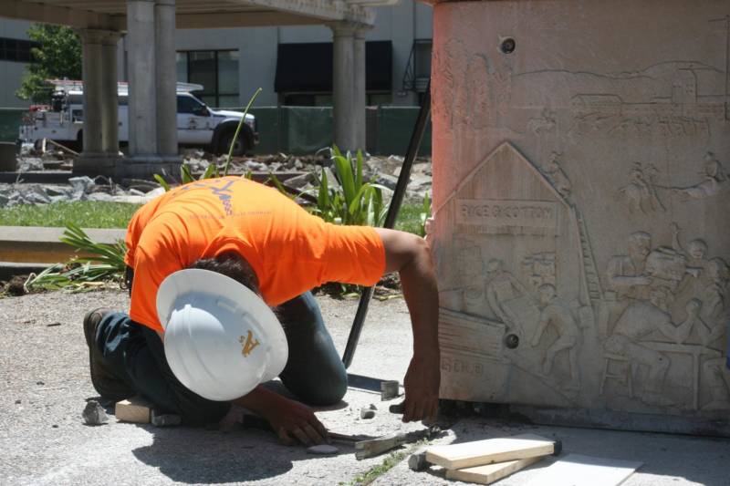 A worker helps remove a panel by artist Ruth Asawa from a fountain in Courthouse Square in Santa Rosa.