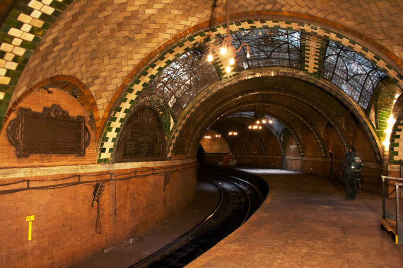 Manhattan's long-shuttered City Hall subway station has hanging chandeliers and arched ceilings that are covered in green and white tiles.