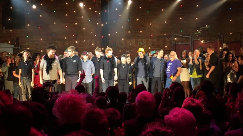 After performing for 24 hours straight, the cast and crew of ‘A 24 Decade History of Popular Music’ take a bow.