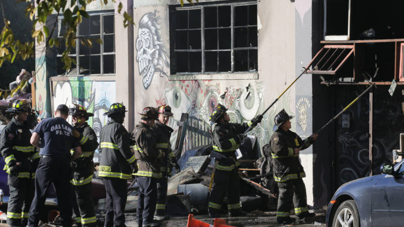 Firefighters work to clear the debris from a doorway following an overnight fire that claimed the lives of at least 36 people at a warehouse in Oakland's Fruitvale neighborhood on Dec 3, 2016.