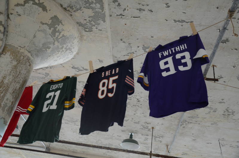 Three jerseys are strung near the ceiling as part of the art installation "Shortening: Making the Irrational Rational on Tuesday, October 25, 2016. The letters on the back of the jersey are a scrambled version of "Off with his head," a reference to the irrational sentences handed down by the Queen of Hearts in Lewis Carroll's "Alice in Wonderland."