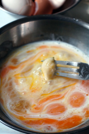 eggs stirring with garlic clove on fork