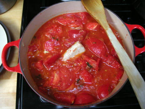 Parm rind in a pot of stewed tomatoes, later to be strained for a soup