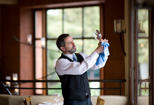 Server Eric Schwier puts a shine on one of the workmanlike wine glasses at Oliveto.