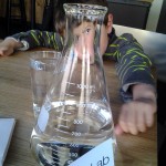 Mary Ladd's son behind H2O beaker at Chocolate Lab