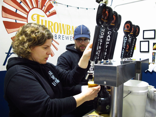 Throwback Brewery co-owner Nicole Carrier and assistant brewer Chris Naro pour beer for customers at their North Hampton, N.H., taproom. Photo: Emily Corwin/NHPR