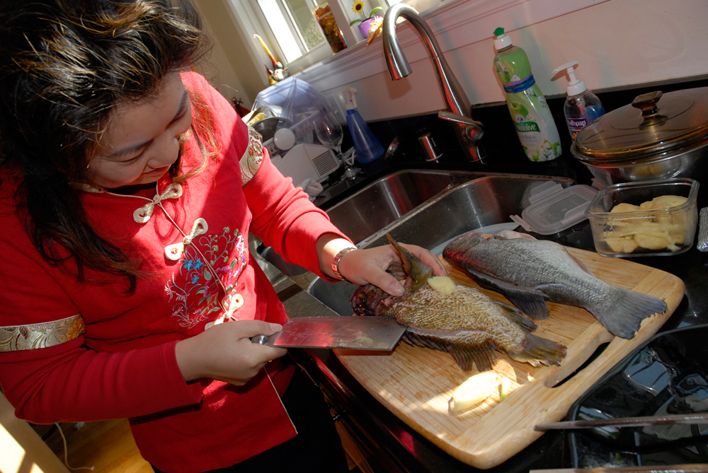 Lisa Li slices whole fish. Photo: Wendy Goodfriend