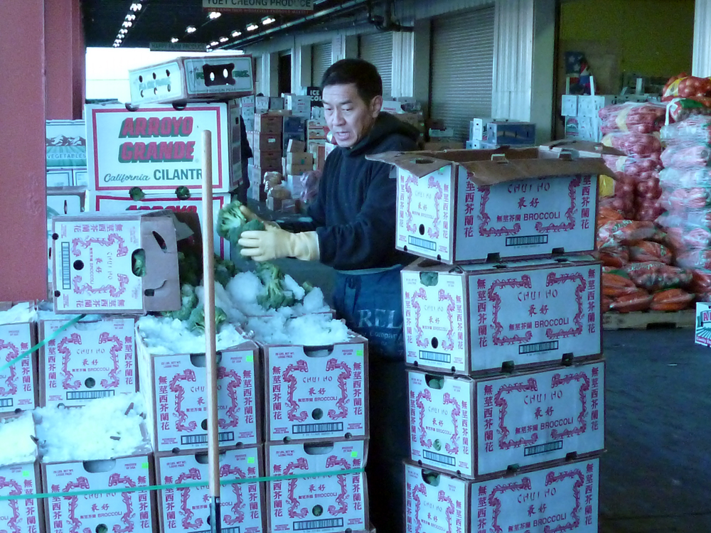 Produce worker with boxes of broccoli