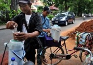 An Indonesian "Starbikes" vendor prepares coffee from his bicycle for street laborers in Jakarta.