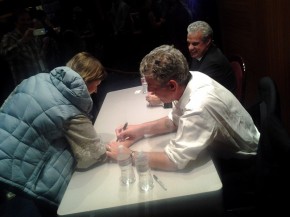 Bourdain signs an arm. Photo: Mary Ladd