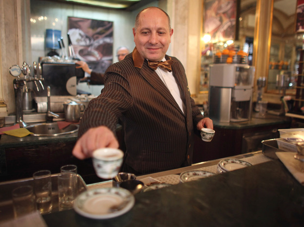 A barista serves coffee at a cafe in Naples, Italy. The Italian city's long-standing tradition of buying a cup for a less-fortunate stranger is now spreading across Europe. Photo: Christopher Furlong/Getty Images