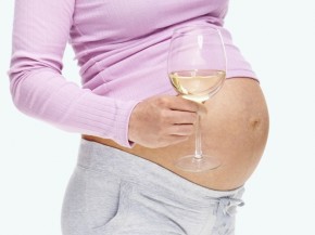 A pregnant woman holds a glass of wine. Photo: iStockphoto.com