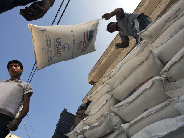 Palestinians unload bags of flour donated by USAID, or the United States Agency for International Development, at a depot in the West Bank village of Anin near Jenin, in 2008. Photo: Mohammed Ballas/AP
