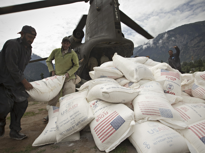 Pakistani aid workers offload USAID food supplies from an Army helicopter in Kallam Valley during catastrophic flooding in 2010. Photo: Behrouz Mehri/AFP/Getty Images