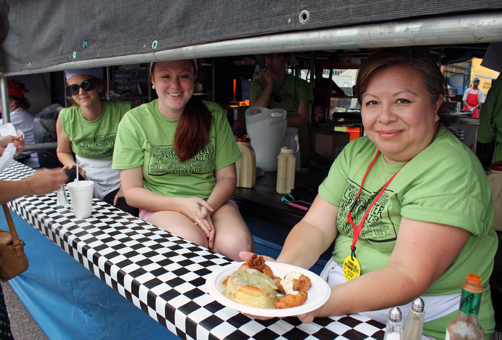 Christine Christy, Haley Marquette and Olga Marquette of Patton’s Caterers serve a combo plate with crawfish beignets, crawfish sack and oyster patties. Credit: Tilde Herrera