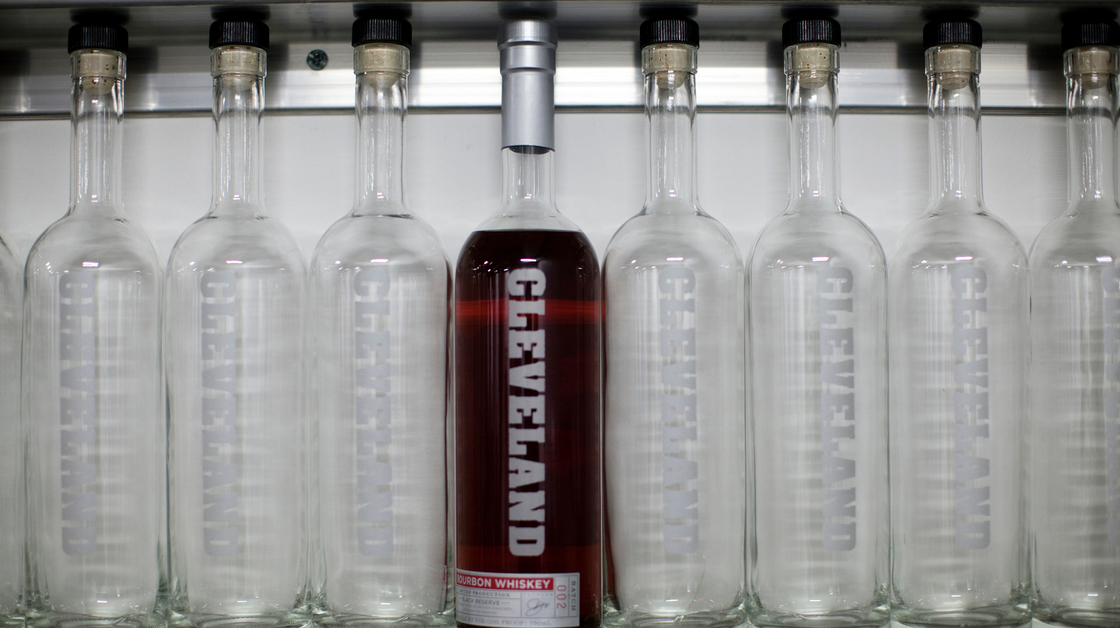 A bottle of Cleveland Whiskey's bourbon sits on a shelf with empty bottles at the company's distillery. Photo: David Kidd