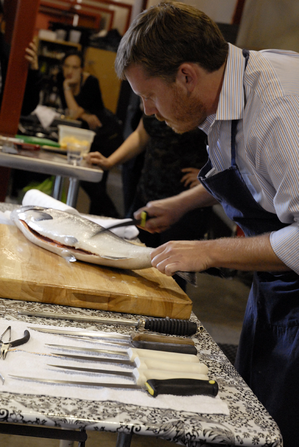 Chef Neil Davidson removing scales from a whole salmon. Photo: Wendy Goodfriend 