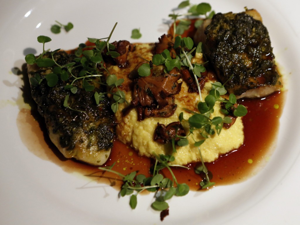 Fillets of chimichurri-crusted red snapper and tilapia, separated by fresh corn polenta. Photo: Heather Rousseau/NPR