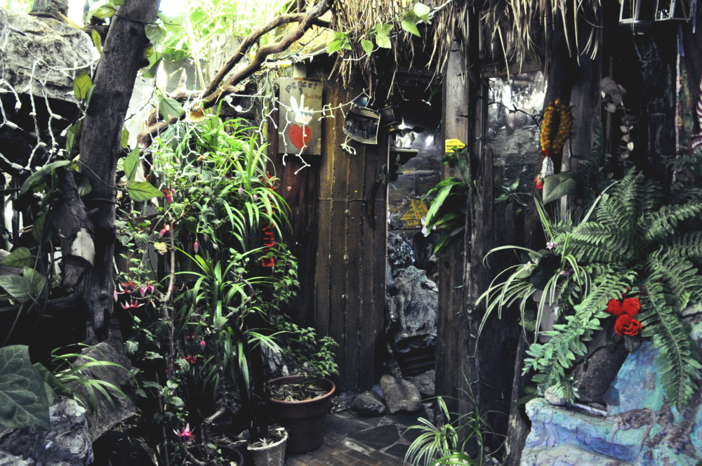 The entrance at Old Weang Ping is covered in vegetation, Buddhist symbols and twinkle lights. Photo: Lauren Benichou