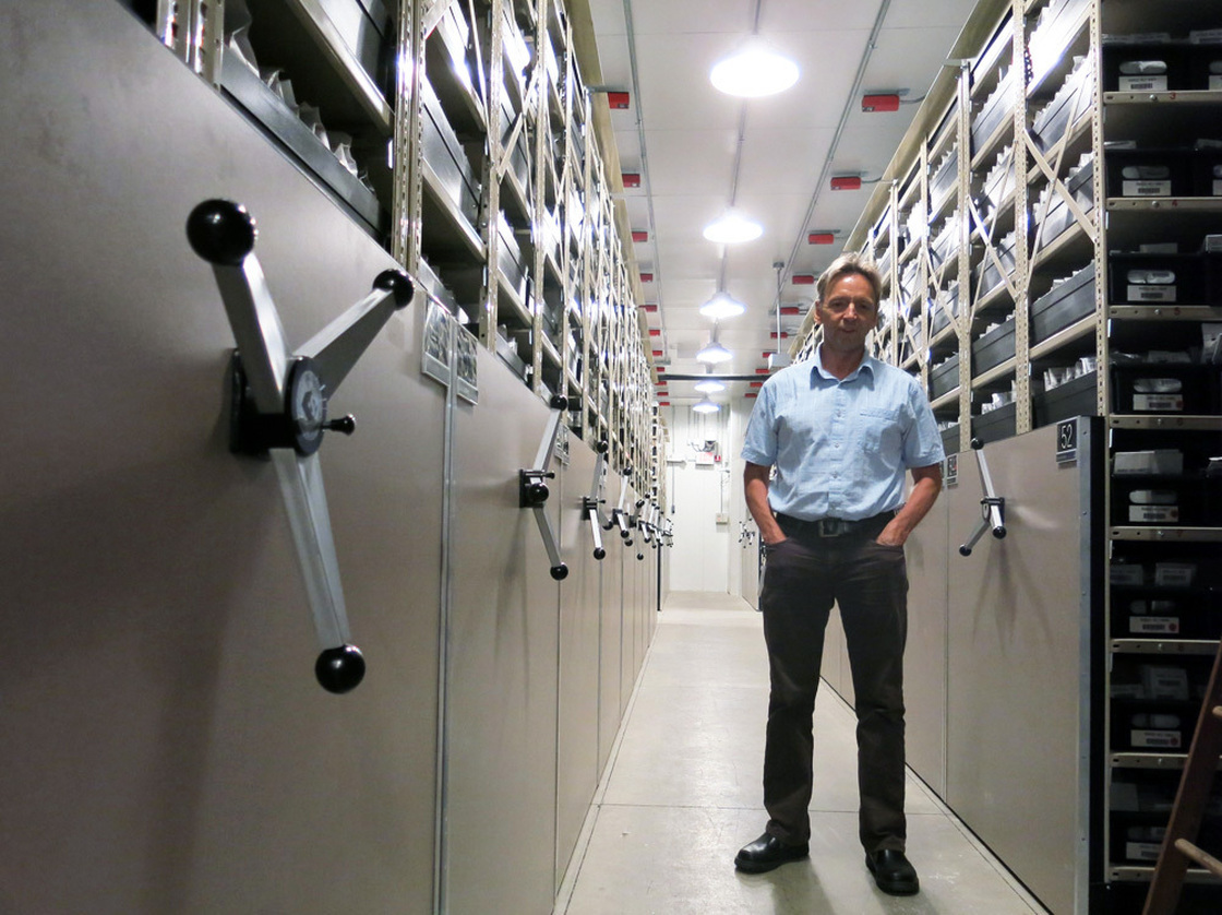 Dave Dierig, research leader at the National Center for Genetic Resources Preservation, stands among the ceiling-high shelves that hold the 600,000 seed packets in this cold storage vault. Photo: Grace Hood/KUNC