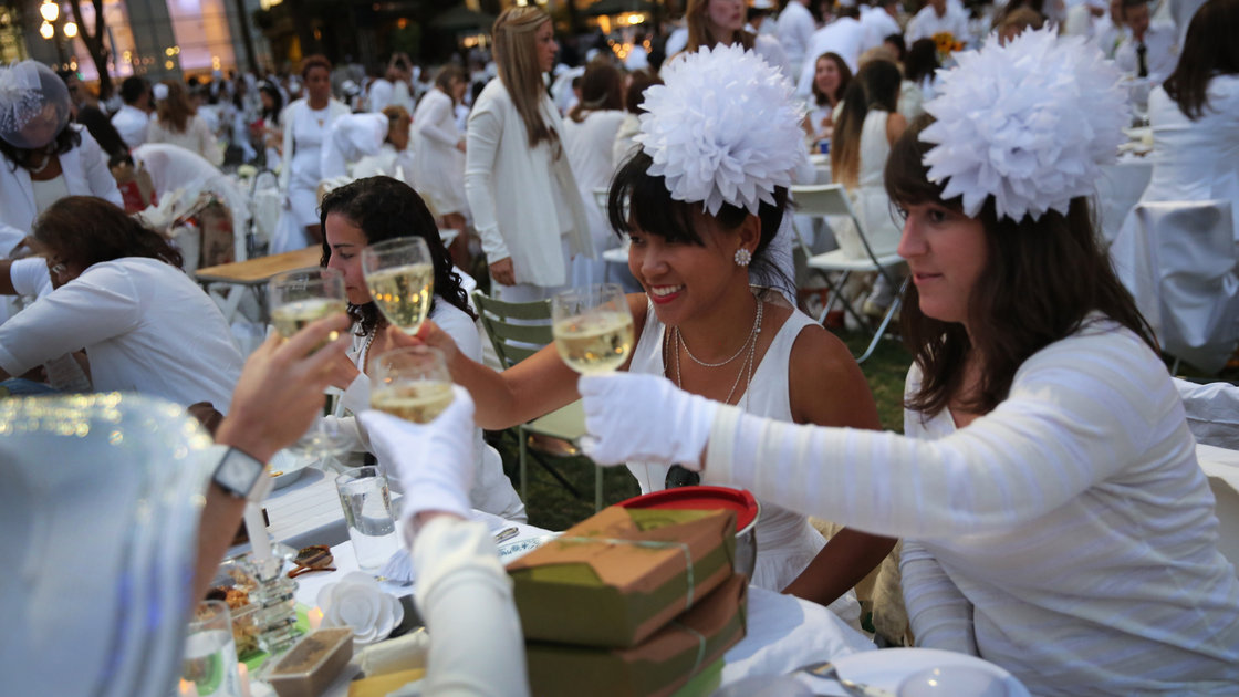 At Diner en Blanc ("Dinner in White"), people arrive dressed all in white. They bring their own food and, fittingly,” white wine. Photo: John Moore/Getty Images