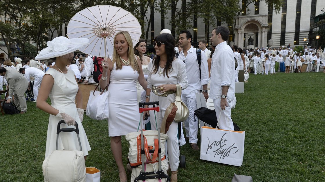 Guests arrive at Bryant Park last Wednesday, toting their dinner and dinnerware with them to the secret pop-up picnic. Photo: Timothy Clary/AFP/Getty Images