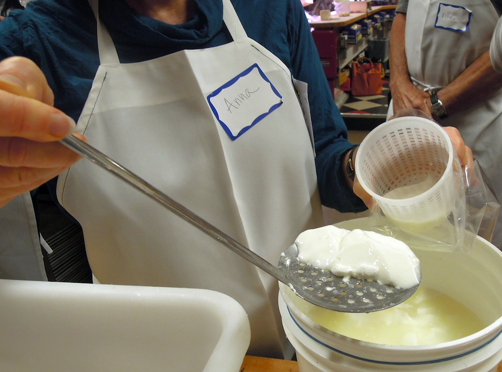 Scooping the curds from the whey.