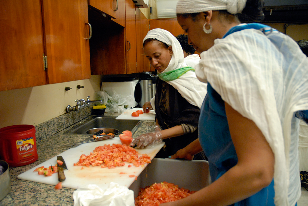 Women prep tomatoes for a salad in the church kitchen. Photo: Wendy Goodfriend