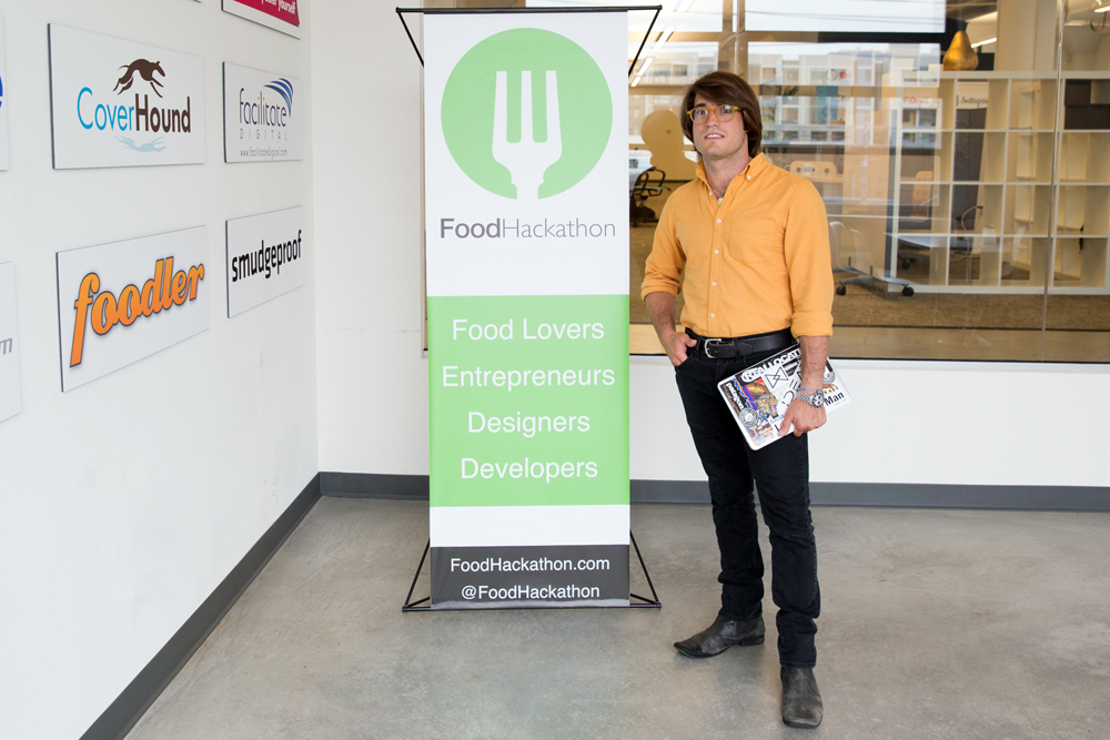 Tim West next to FoodHackathon signage. Photo courtesy of Molly DeCoudreaux