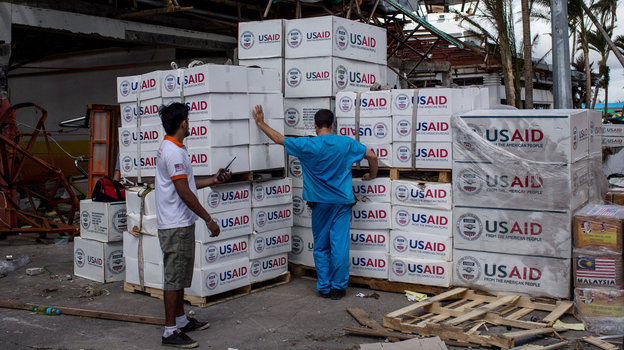 A relief worker looks over boxes of aid provided by the U.S. on November 14, 2013 in Leyte, Philippines. Proponents of food aid reform say it makes more sense for the U.S. to buy food donations locally than ship them across the globe. Photo: Chris McGrath/Getty Images