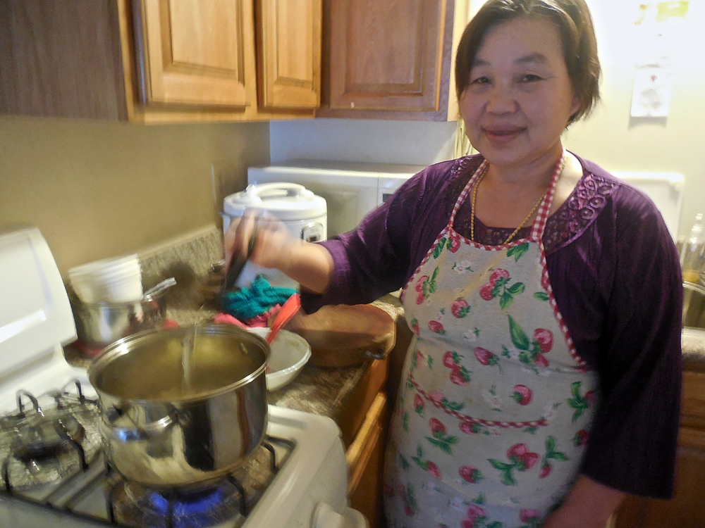 Cho Mei's mother, Naw Htoo prepares a traditional Karen soup with chicken, lemongrass, cilantro and spices at their home in Oakland. Photo: Shuka Kalantari