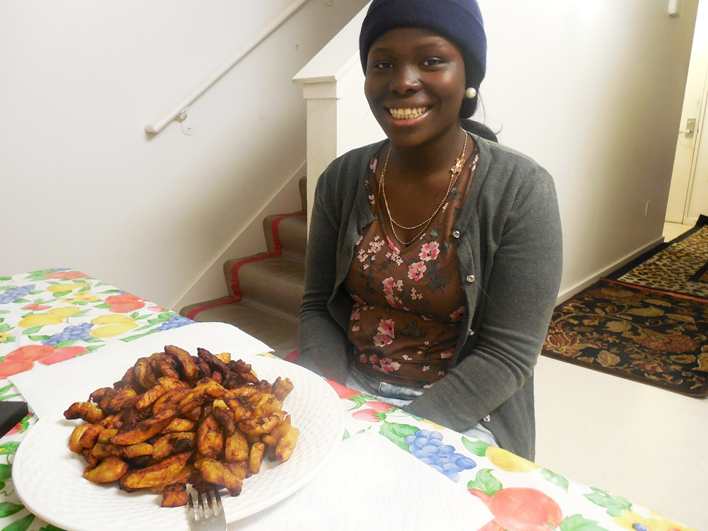 Patience Wilson proudly poses in front of the plantain dish she will prepare for Christmas dinner. Photo: Shuka Kalantari