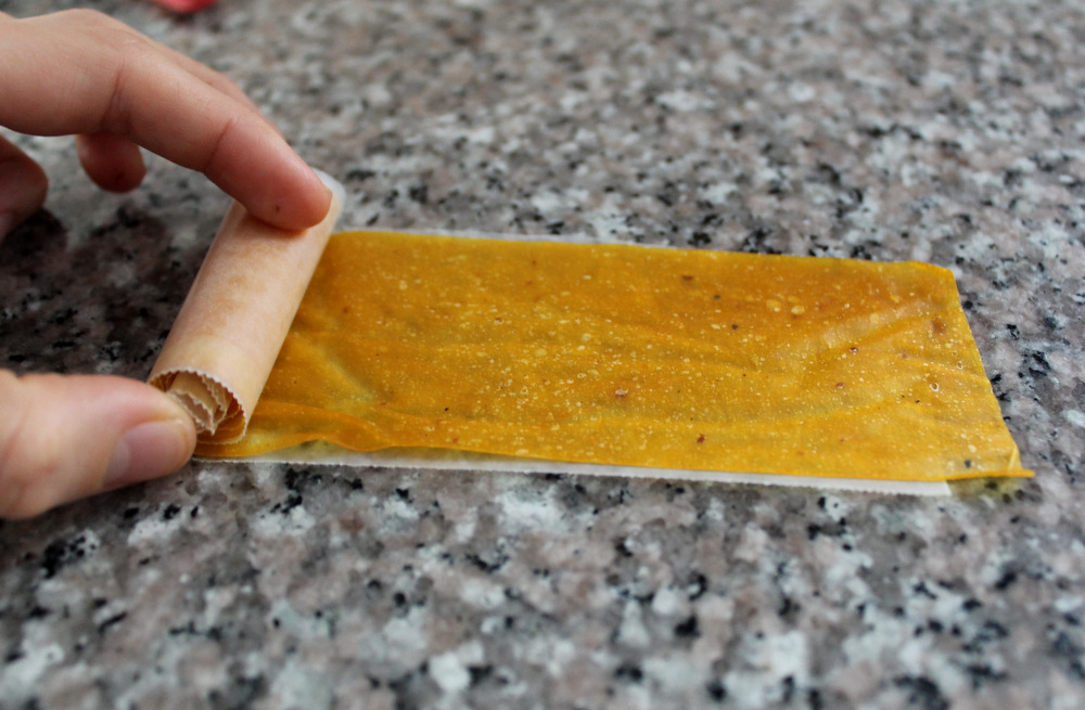 Roll the cooled and cut fruit roll-ups on a sheet of waxed paper. Photo: Kate Williams