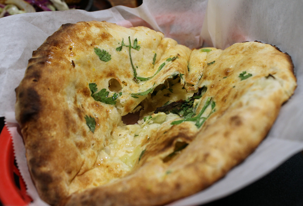 Onion kulcha is naan bread stuffed with sautéed onions and a generous handful of cilantro. Photo: Kate Williams