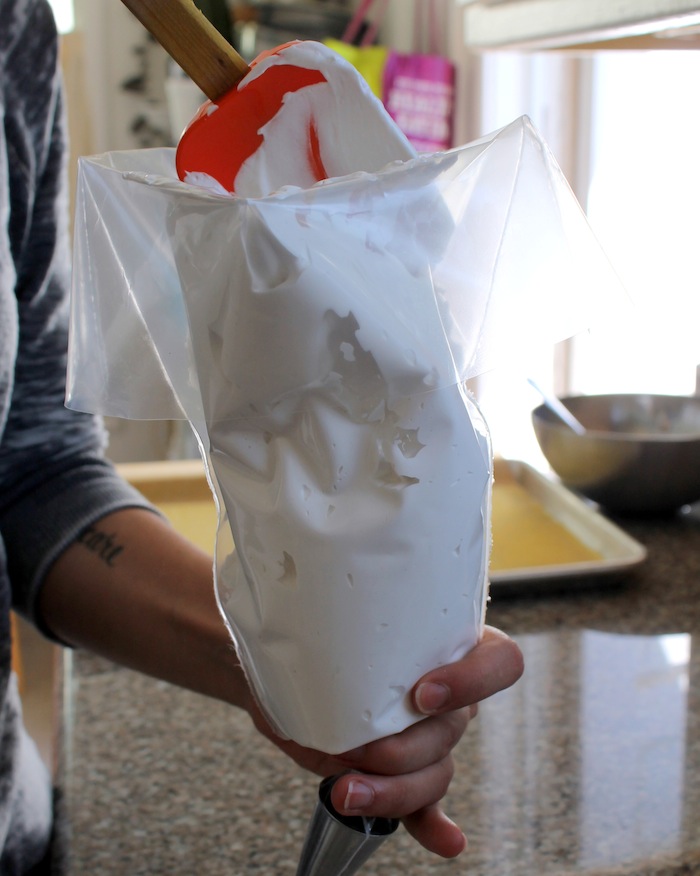 Be sure to twist and pinch the bottom of the piping bag to prevent the marshmallow mixture from leaking out while it is being added to the piping bag. Photo: Kate Williams