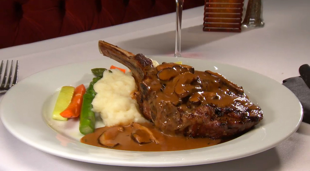 Massimo's Marinated Veal Chop with mushroom sauce served with garlic mashed potatoes and fresh vegetables